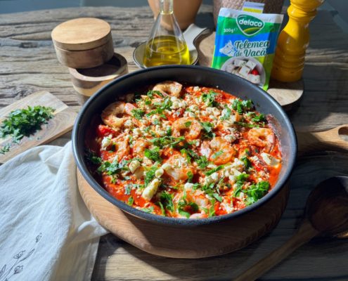 Creveți saganaki gătiți în sos de roșii și usturoi, cu telemea de vacă Delaco sfărâmată deasupra