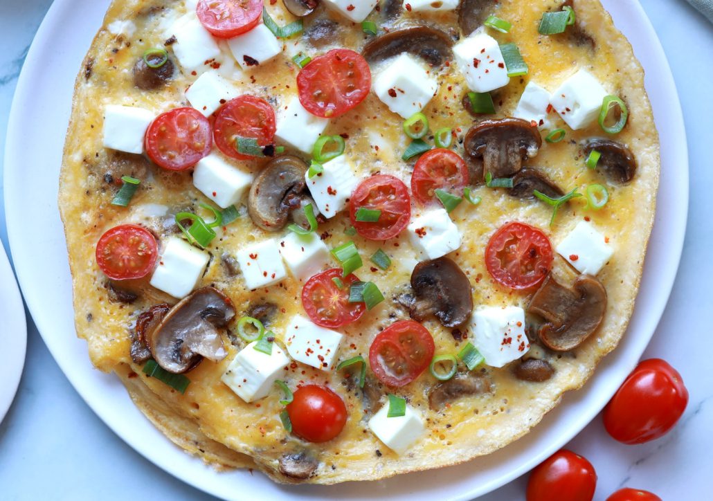 Omletă pufoasă cu telemea de oaie Delaco în saramură, decorată cu verdeață proaspătă