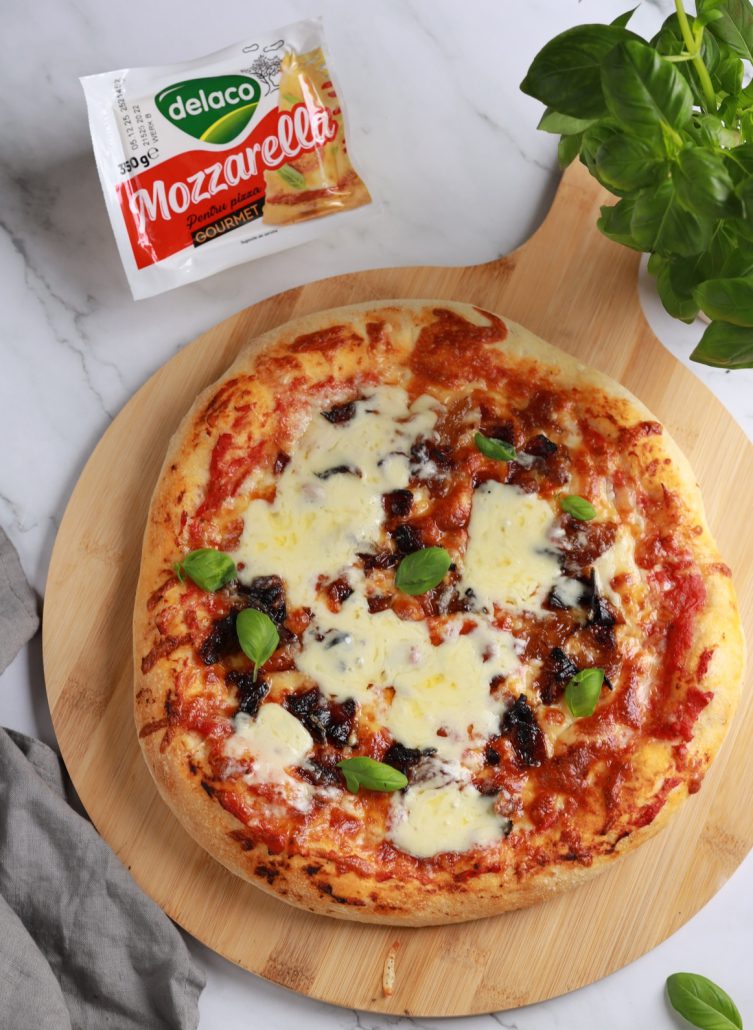 Pizza de casă cu mozzarella Delaco, ceapă caramelizată și bacon crocant