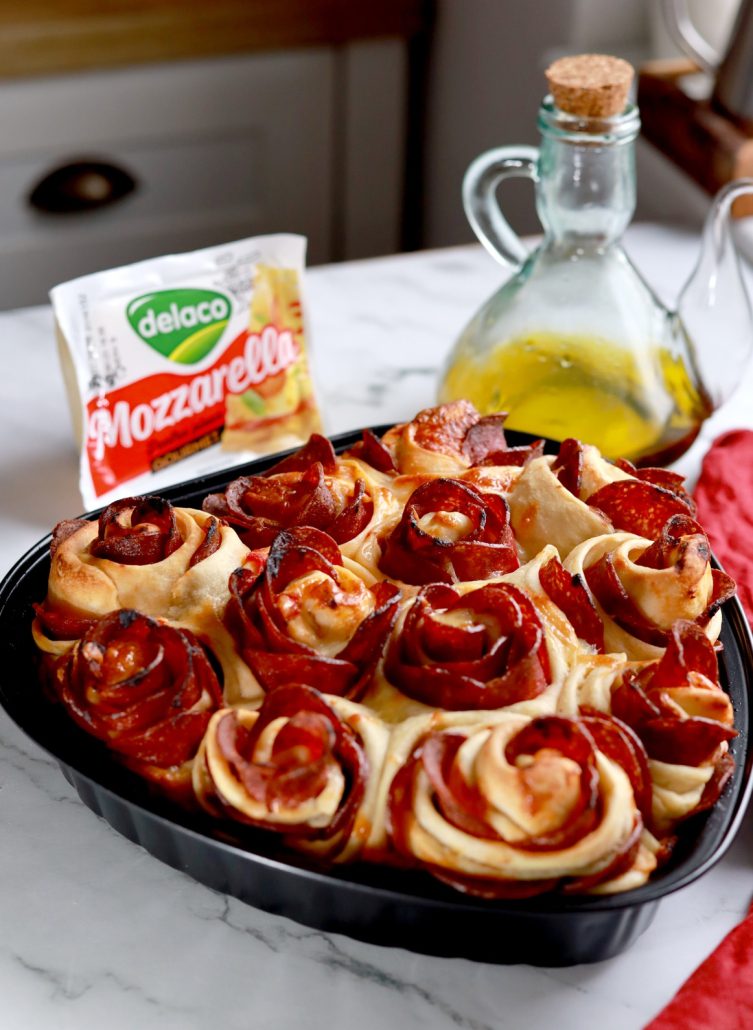 Detaliu cu trandafiri din salam și mozzarella topită pe pizza romantică în formă de inimă