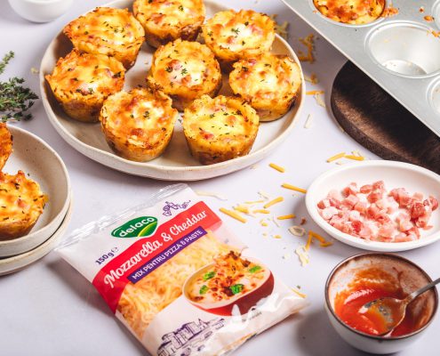 Cartofi gratinați în forme de brioșe cu bacon și Mix de Mozzarella & Cheddar, serviți pe farfurie