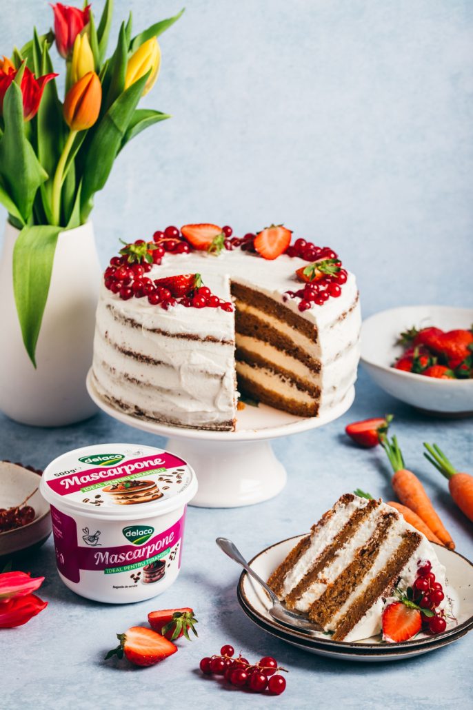 felie de carrot cake cu crema de mascarpone si fructe proaspete pe farfurie