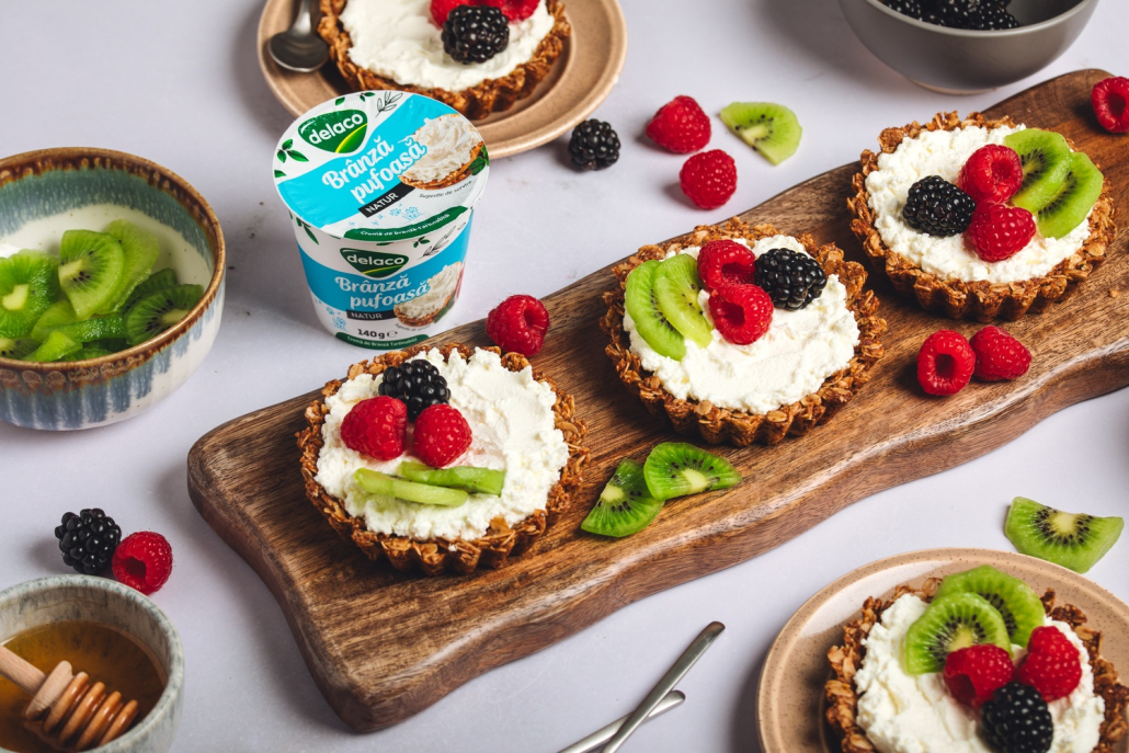 Tarte granola cu Brânză Pufoasă Delaco, decorate cu kiwi, zmeură și mure proaspete.