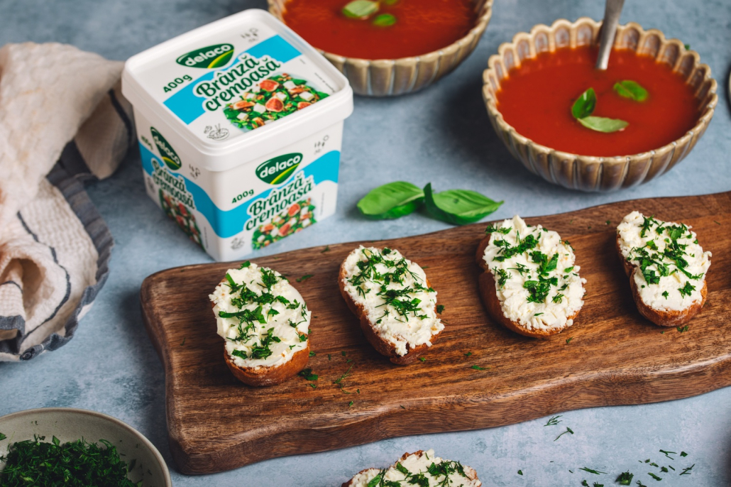 Bruschete cu Brânză Cremoasă Delaco și ierburi aromatice, servite alături de supă-cremă de roșii.
