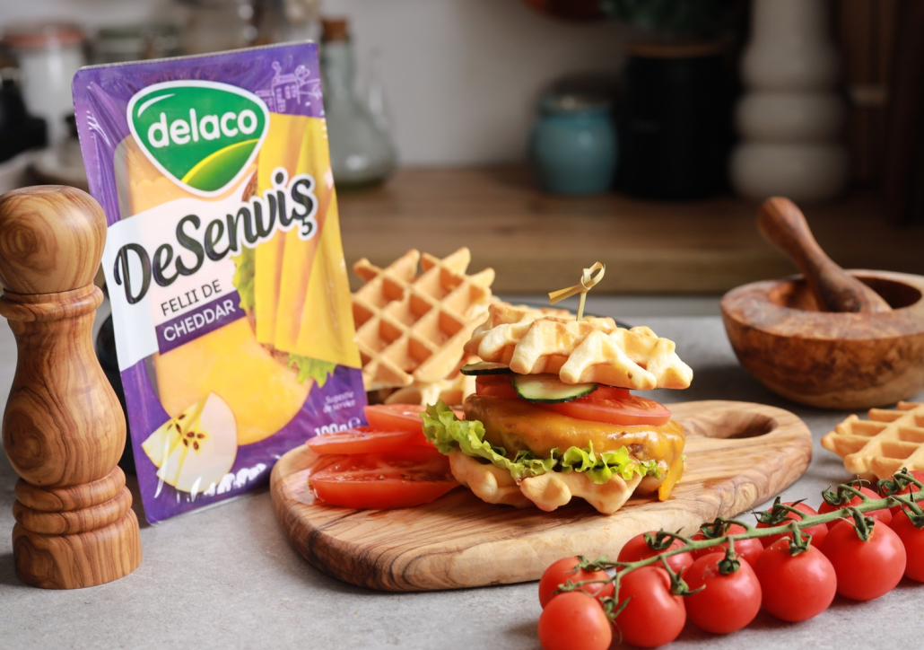 Waffle burger cu Cheddar DeSenviș, salată, roșii și castraveți